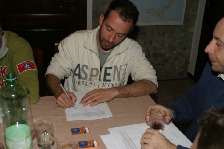 Un socio firma un documento al tavolo